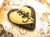 Bouton gros coeur noir et petit coeur ocre jaune