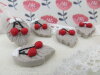 Bouton cerises rouges sur feuille beige