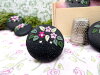 Bouton rond noir petites fleurs roses